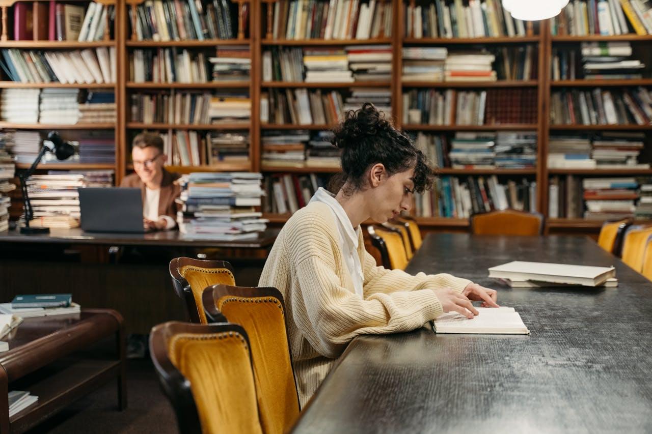 Человек читает книгу за столом